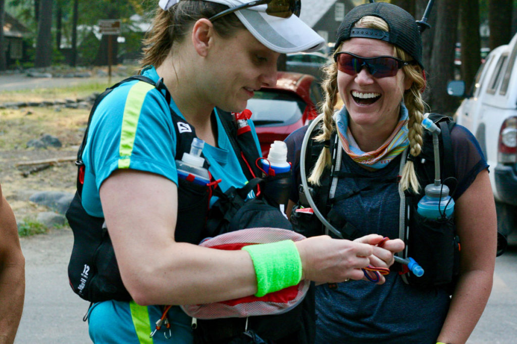 Two women prep gear for their run ahead.