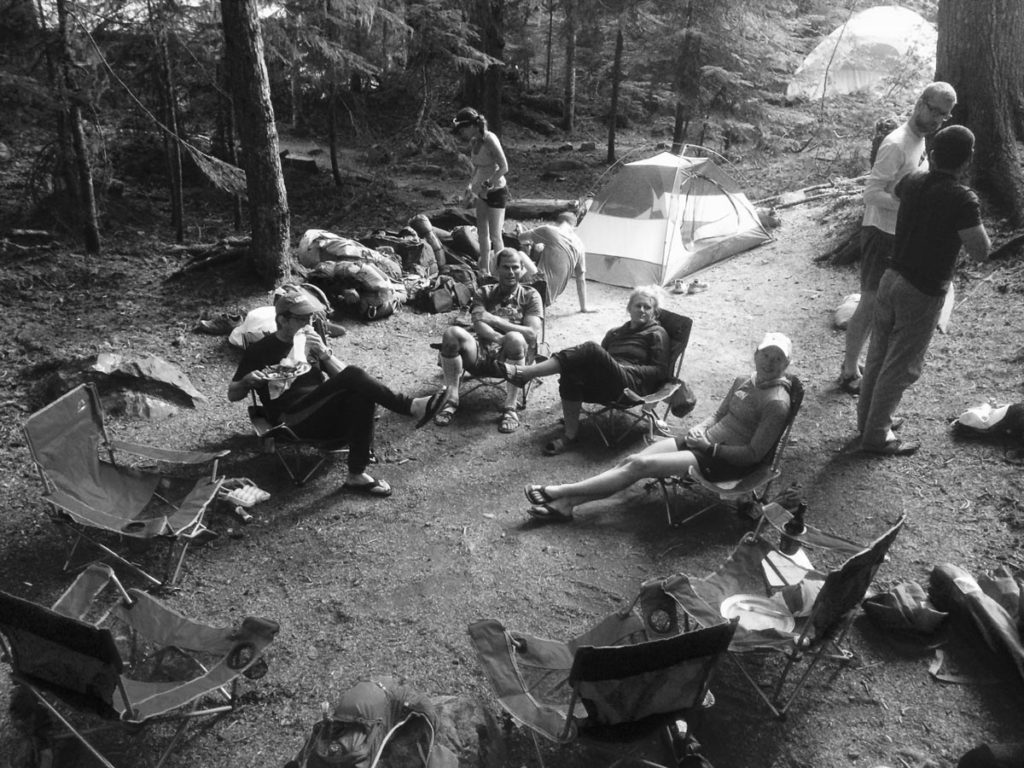 A group gathers around camp, lounging after a long day.