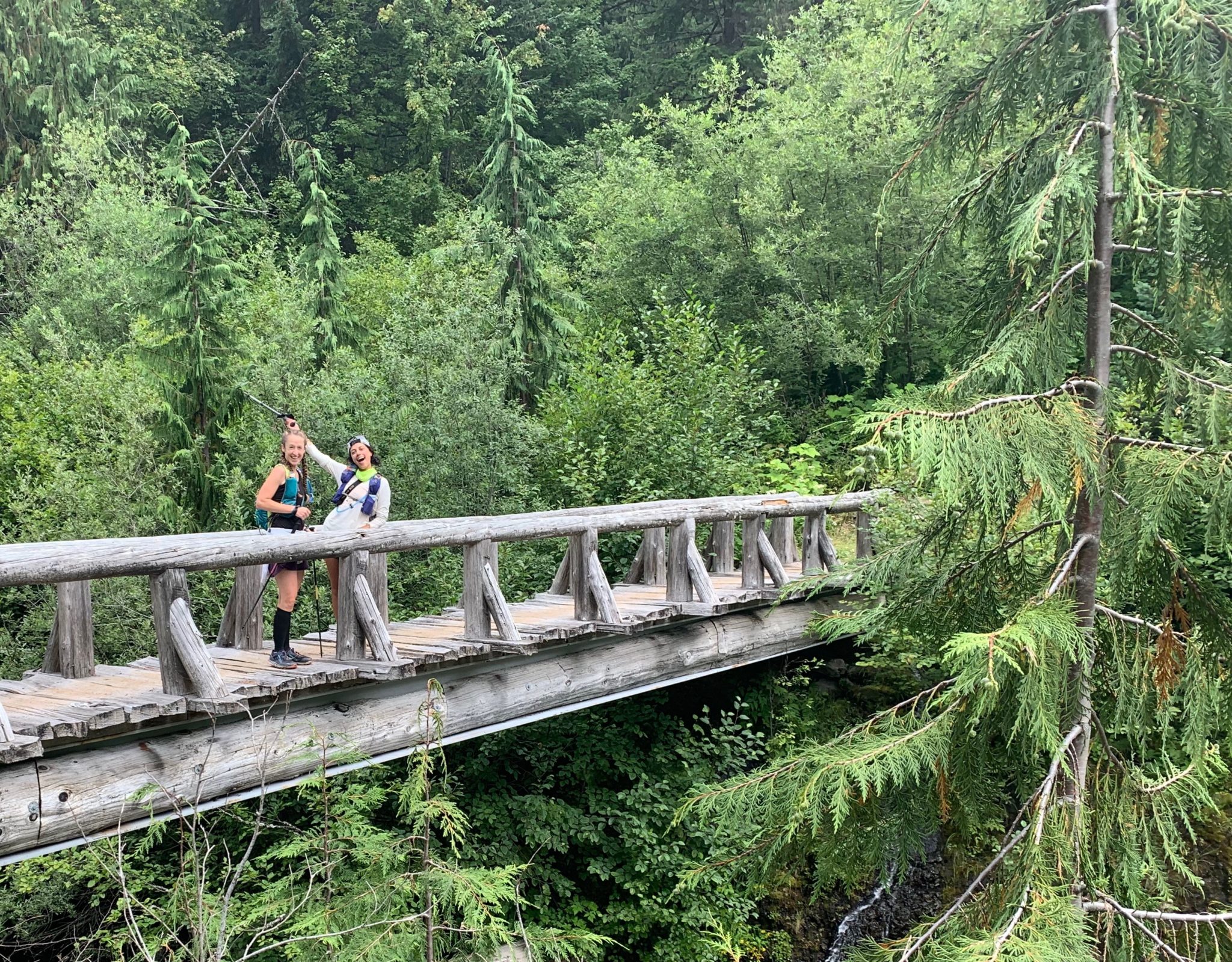 two trail runners crossing a bridge in Mt. Rainier National Park