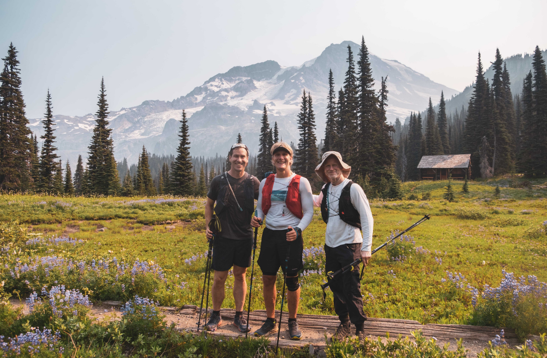Dan Berlin and his crew pose for the camera, with Tahoma towering overhead and Indian Henry's cabin in the background.