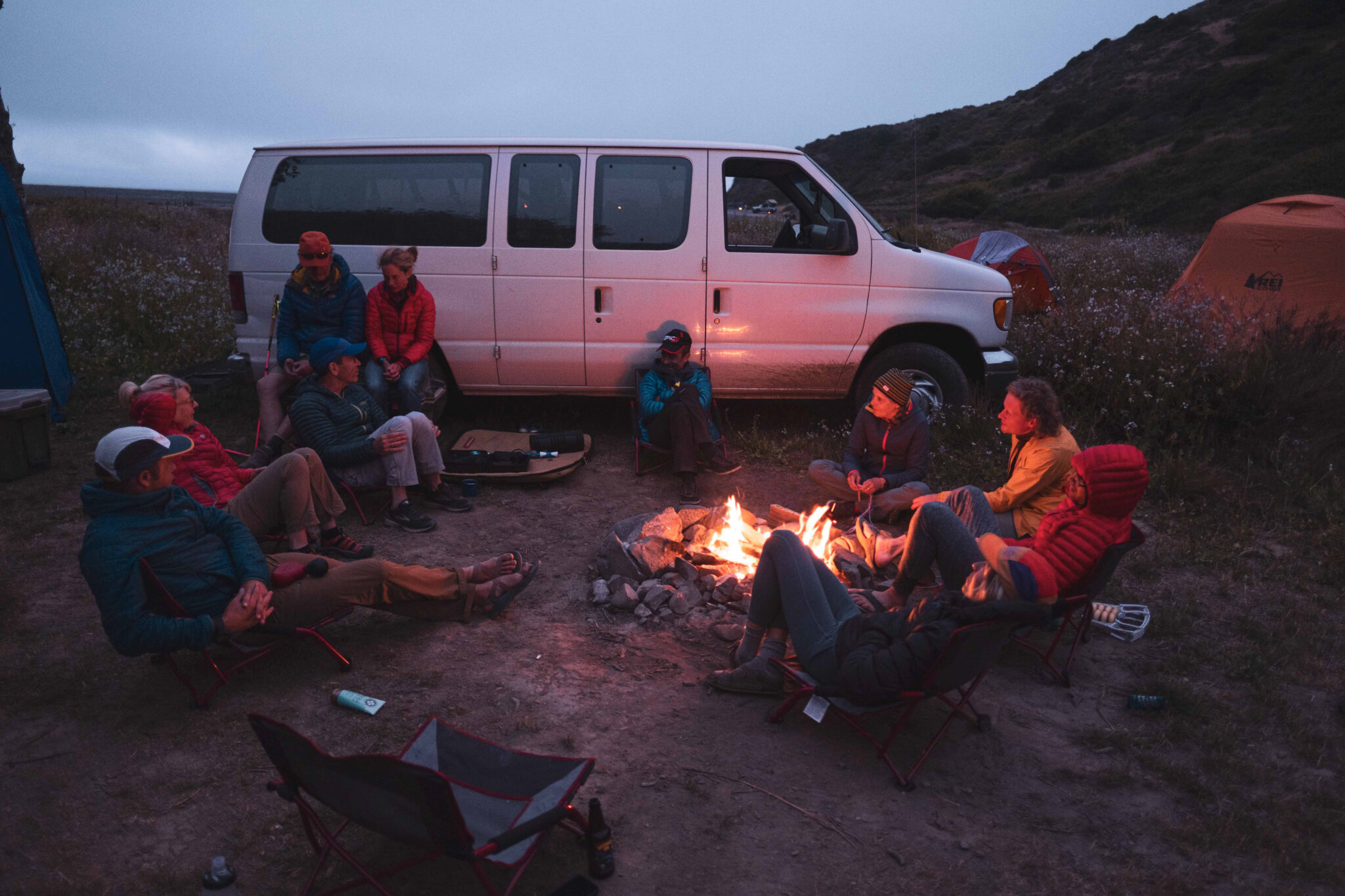 Image shows runners relaxing by the fire at Usal Beach.